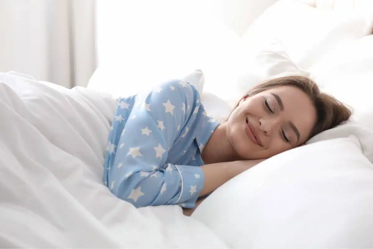 Woman resting comfortably in bed after nasal surgery addressing obstructive sleep apnea symptoms